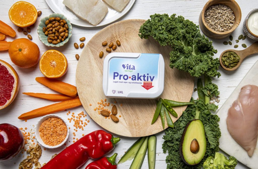 vita hjertego proaktiv på trefjøl omgitt av grønnsaker