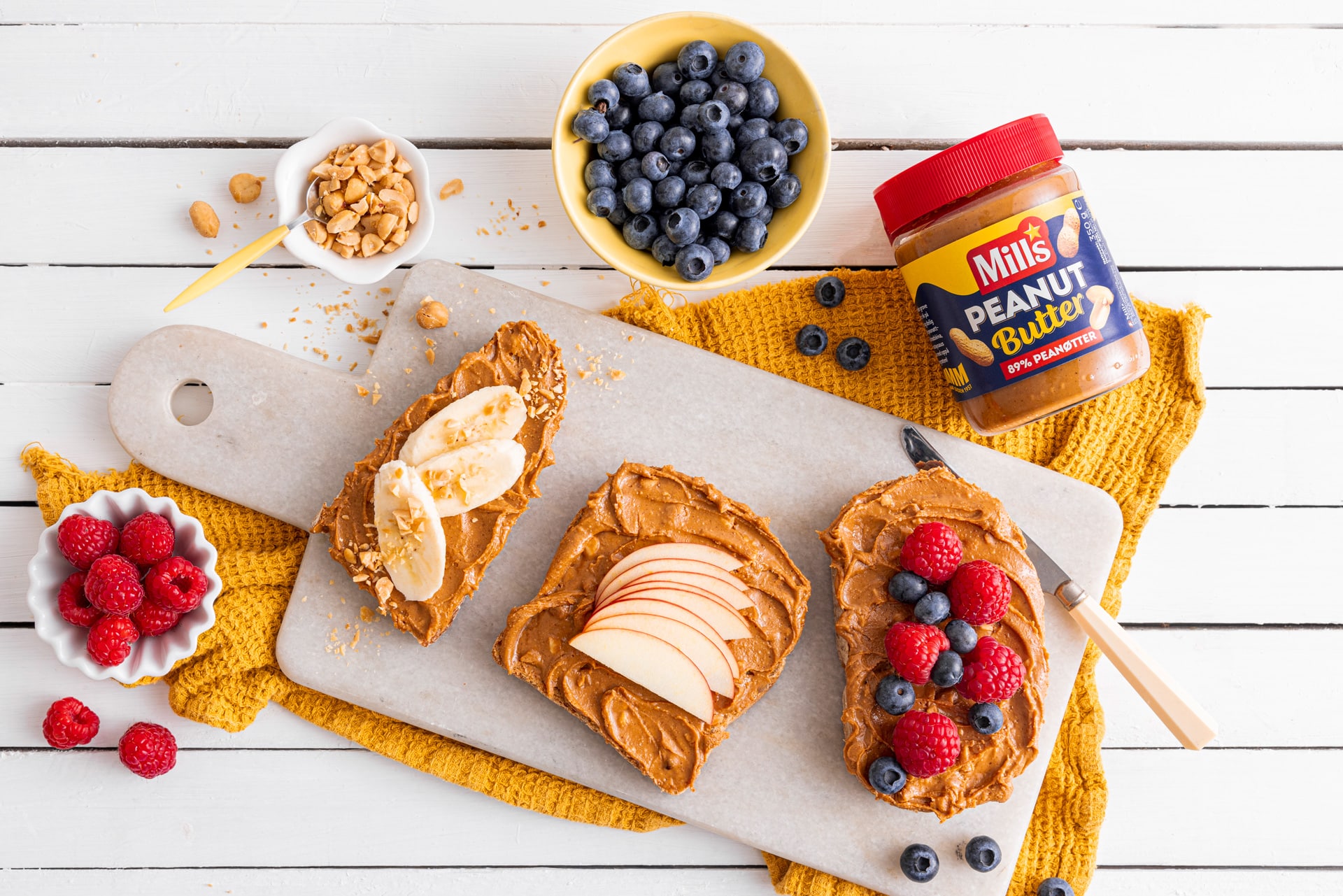 Glass med Mills Peanut Butter og skiver med Mills Peanut Butter