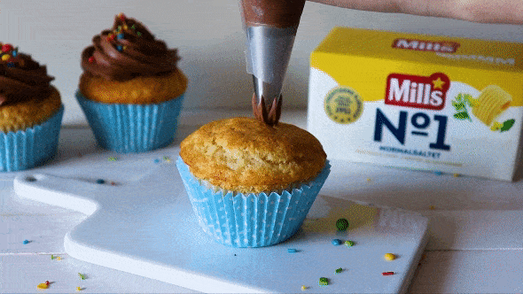 Sjokoladeglasur sprøytes på muffins i lekker rose