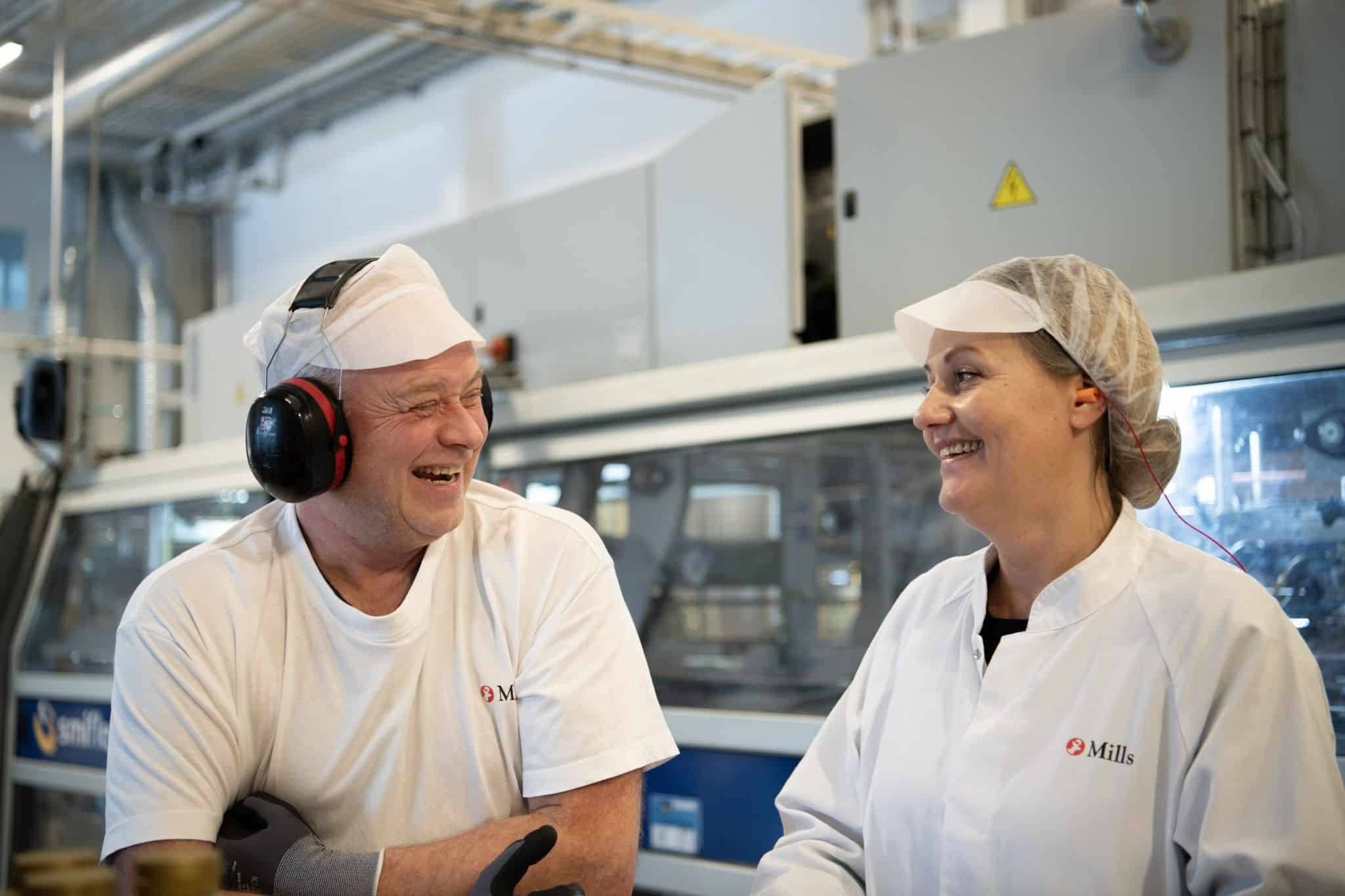 Smilende ansatte på jobb i fabrikk