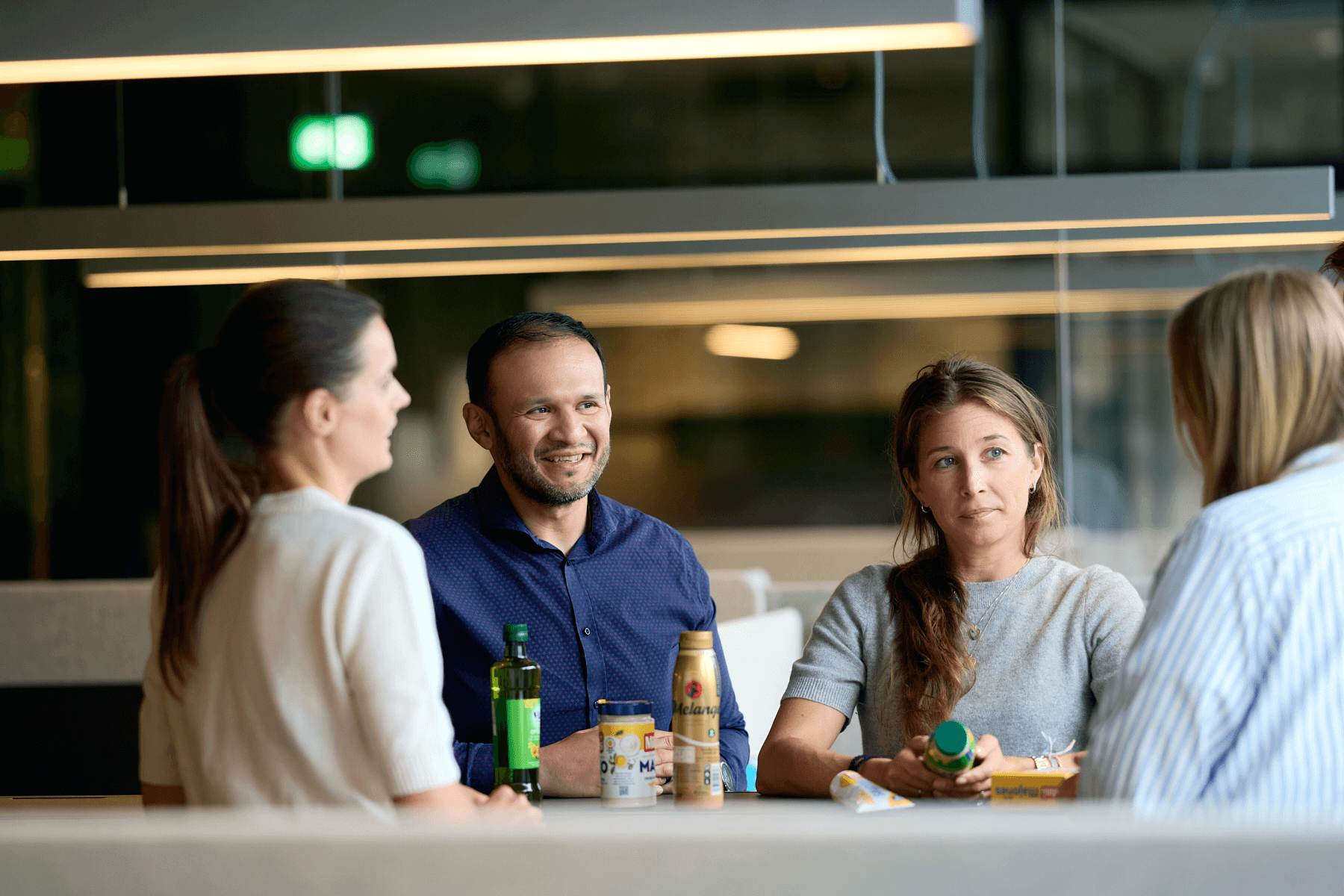 fire ansatte diskuterer over pulten